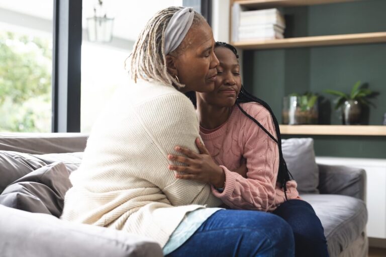 Older woman hugging her daughter.