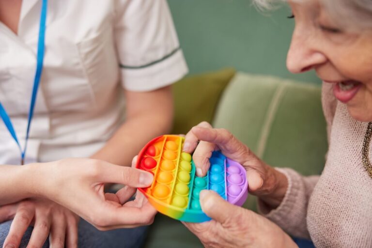 Older woman holding a colorful toy.