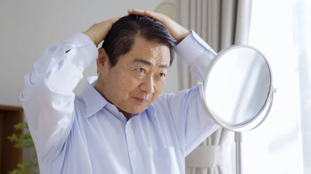 Man looking at himself in the mirror and fixing his hair