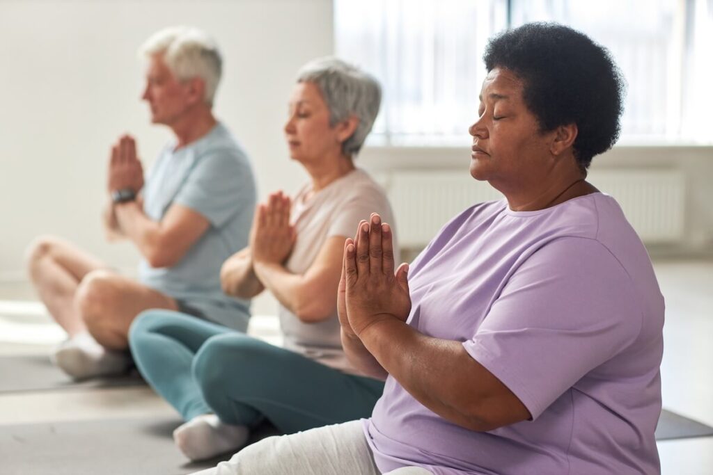 A group of older adults practicing mindfulness exercises together