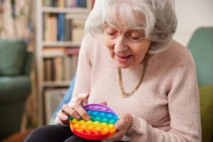 Older woman with dementia using a colorful toy to keep the brain sharp