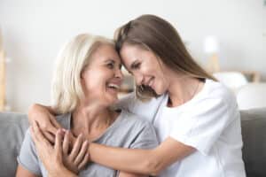 Adult daughter hugging her elderly mother